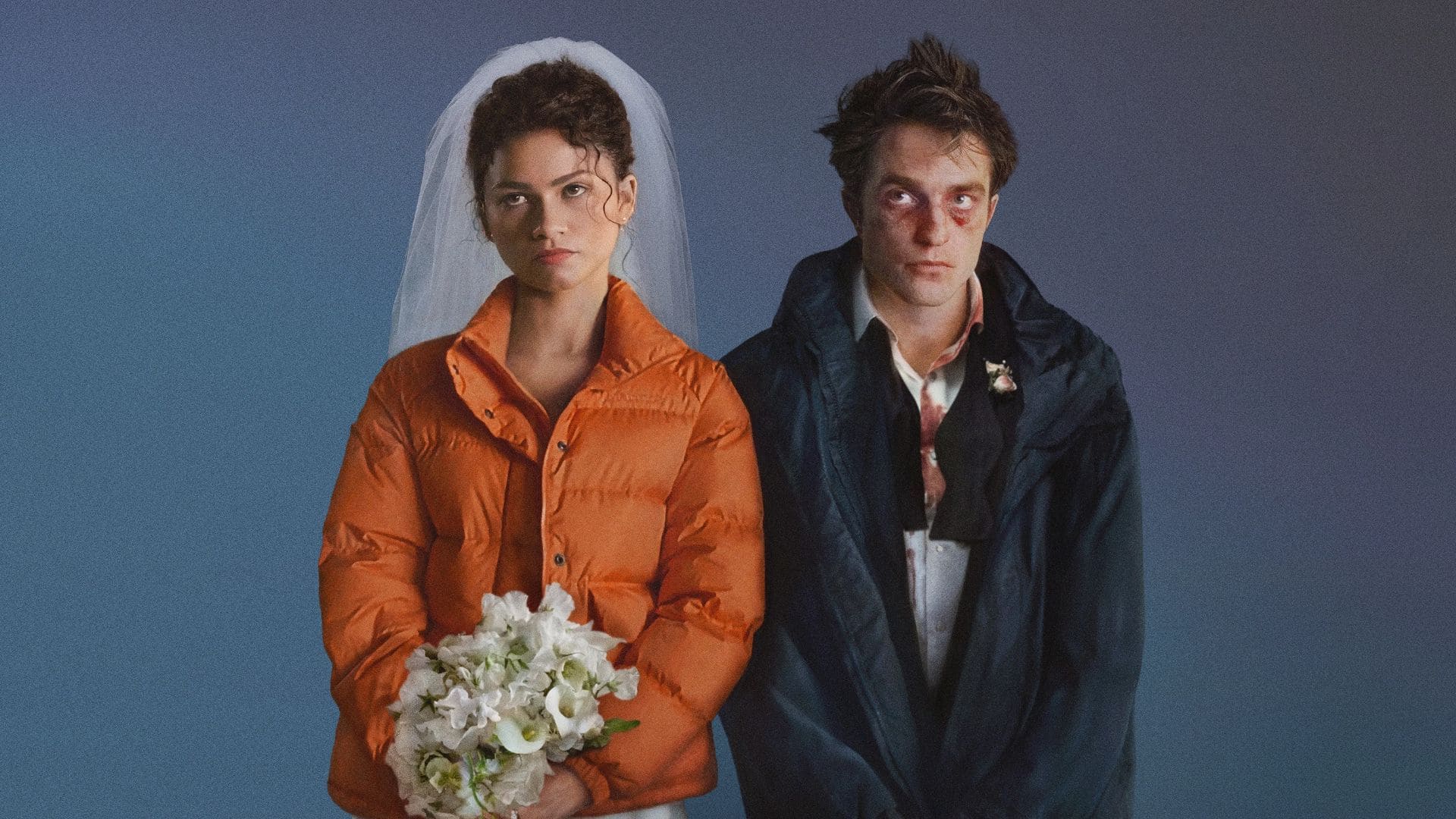 Imagem promocional do filme O Drama, com Emma (Zendaya) de cara fechada vestida com uma jaqueta laranja e véu de noiva, segurando um buquê de flores brancas, e Charlie (Robert Pattinson) olhando pra cima com um casaco escuro sobre um terno ensanguentado e com marcas roxas ao redor dos olhos.
