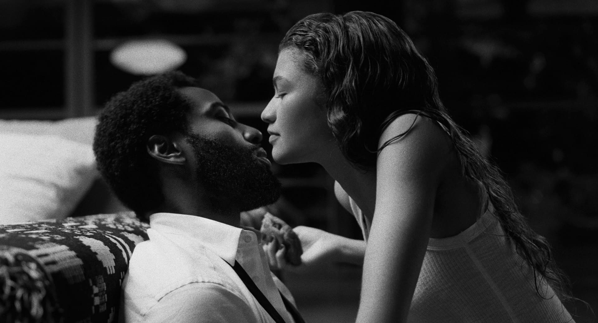 Cena do filme Malcolm & Marie, com Marie (Zendaya) com o rosto bem próximo do rosto de Malcolm (John David Washington) enquanto está sentada no colo dele.