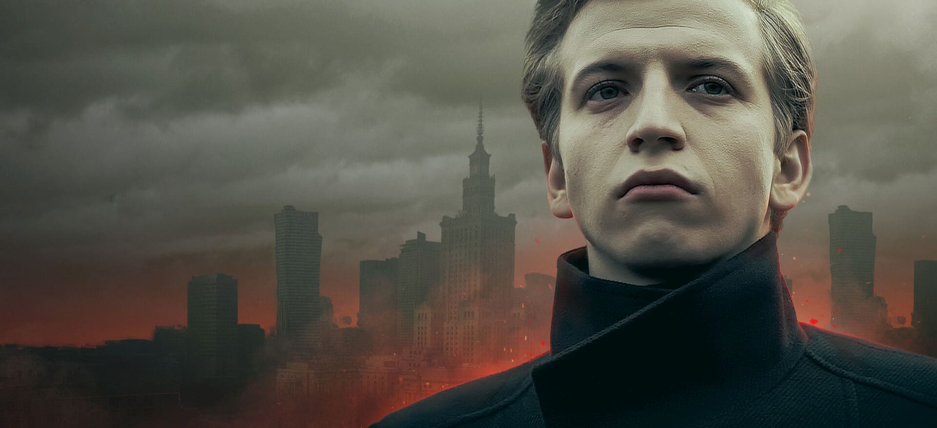 Imagem promocional do filme Rede de Ódio, com Tomasz Giemza (Maciej Musiałowski) em primeiro plano, usando um casaco preto de gola alta, diante de uma cidade sob um céu escuro e avermelhado.