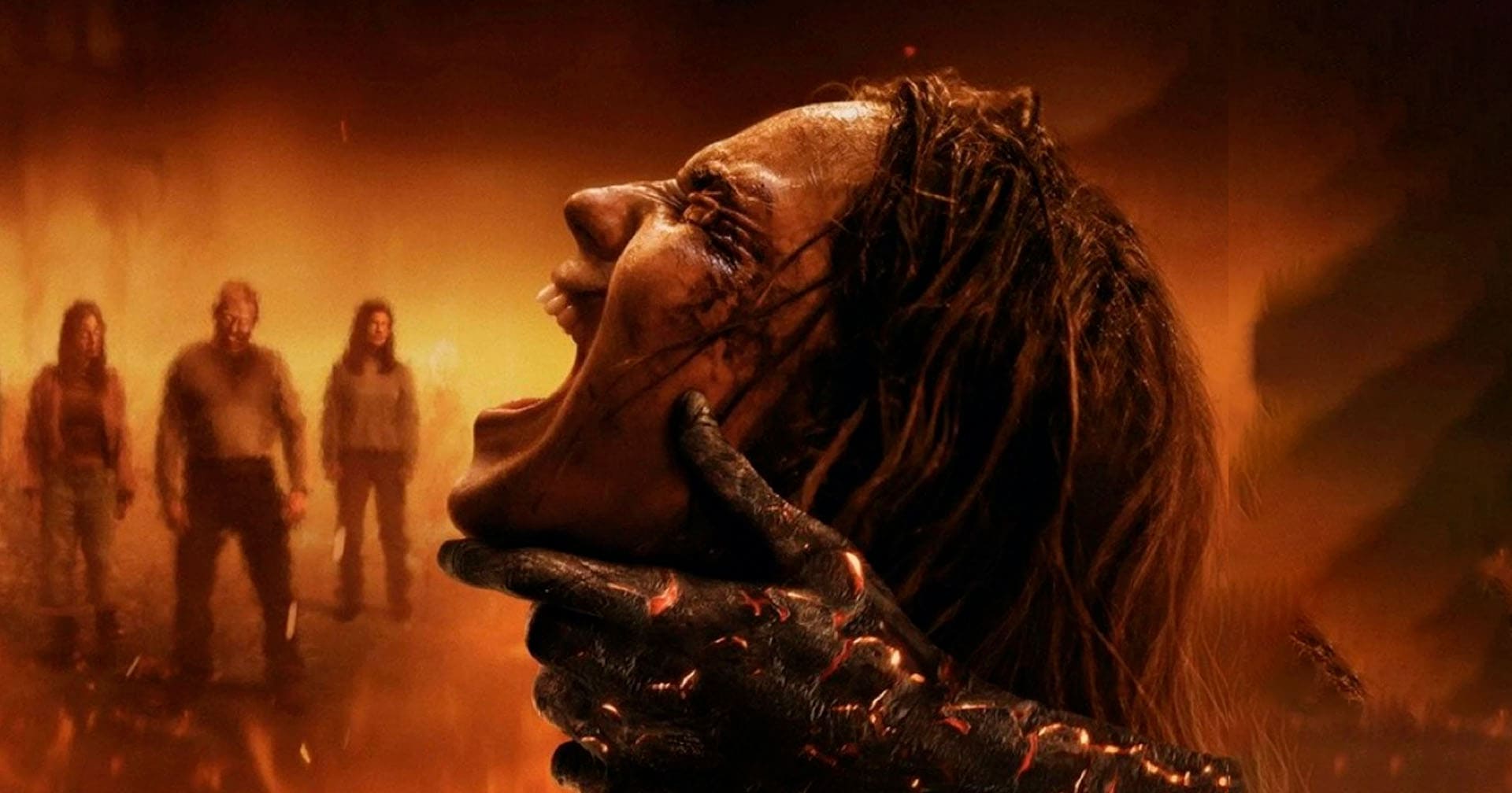Imagem promocional do filme A Morte do Demônio: Em Chamas, com a personagem Alice (Souheila Yacoub) gritando enquanto é atacada por uma criatura com a mão queimada e três pessoas aparecem borradas ao fundo, em meio a um ambiente tomado por fogo e fumaça.