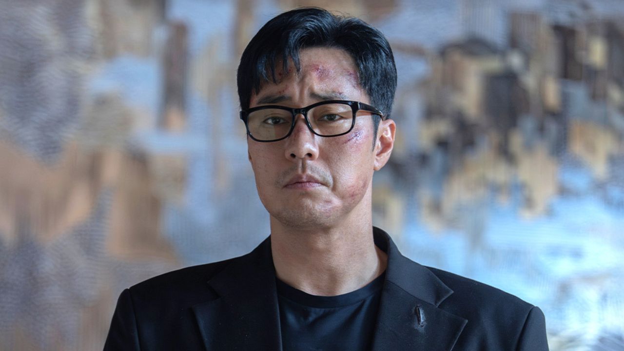 Kim Do-hyeon (So Ji-sub) com o rosto machucado e terno preto rasgado em cena de Agente Kim: Reativado